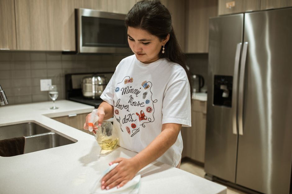 Professional wiping a kitchen counter during deep cleaning