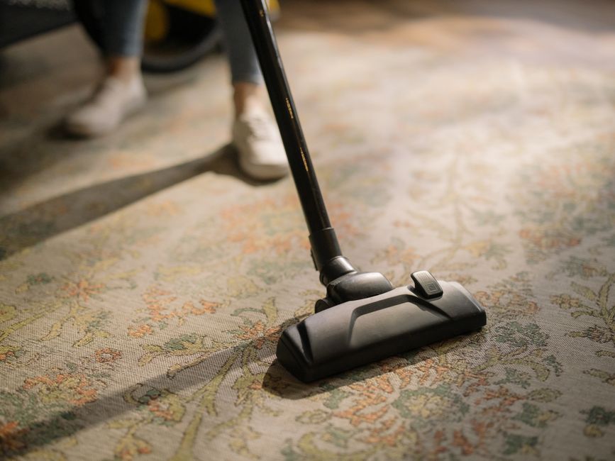 Maid vacuuming a carpet floor